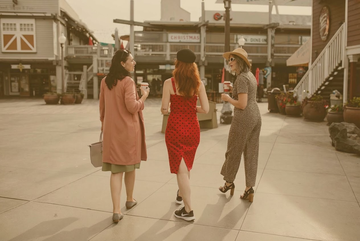 elegant women walking on street and drinking takeaway coffee